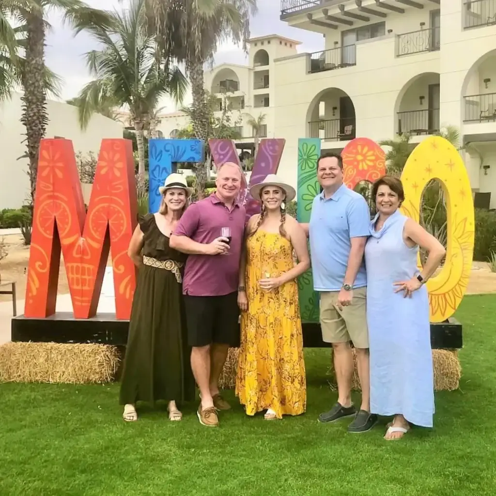 a group of people standing in front of a sign.