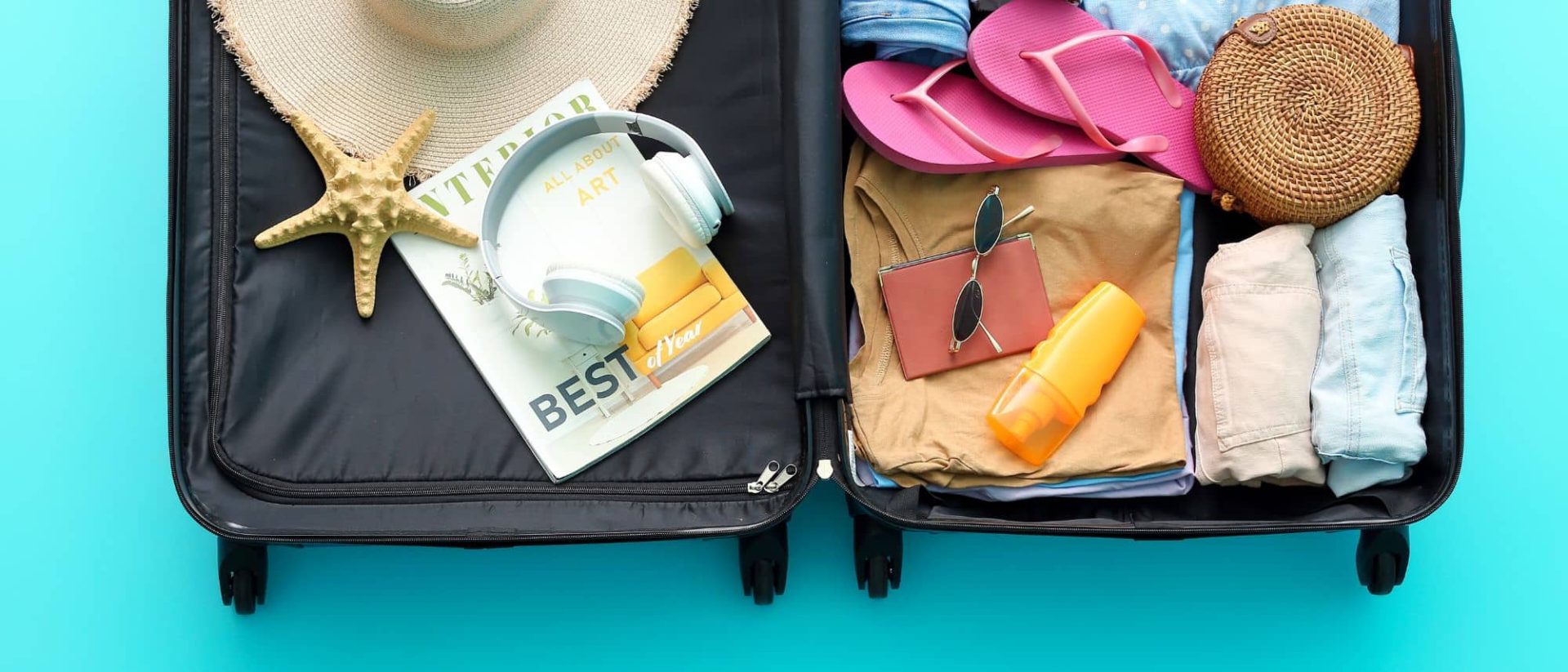 a suitcase filled with clothes, hats, and other items on a blue background.