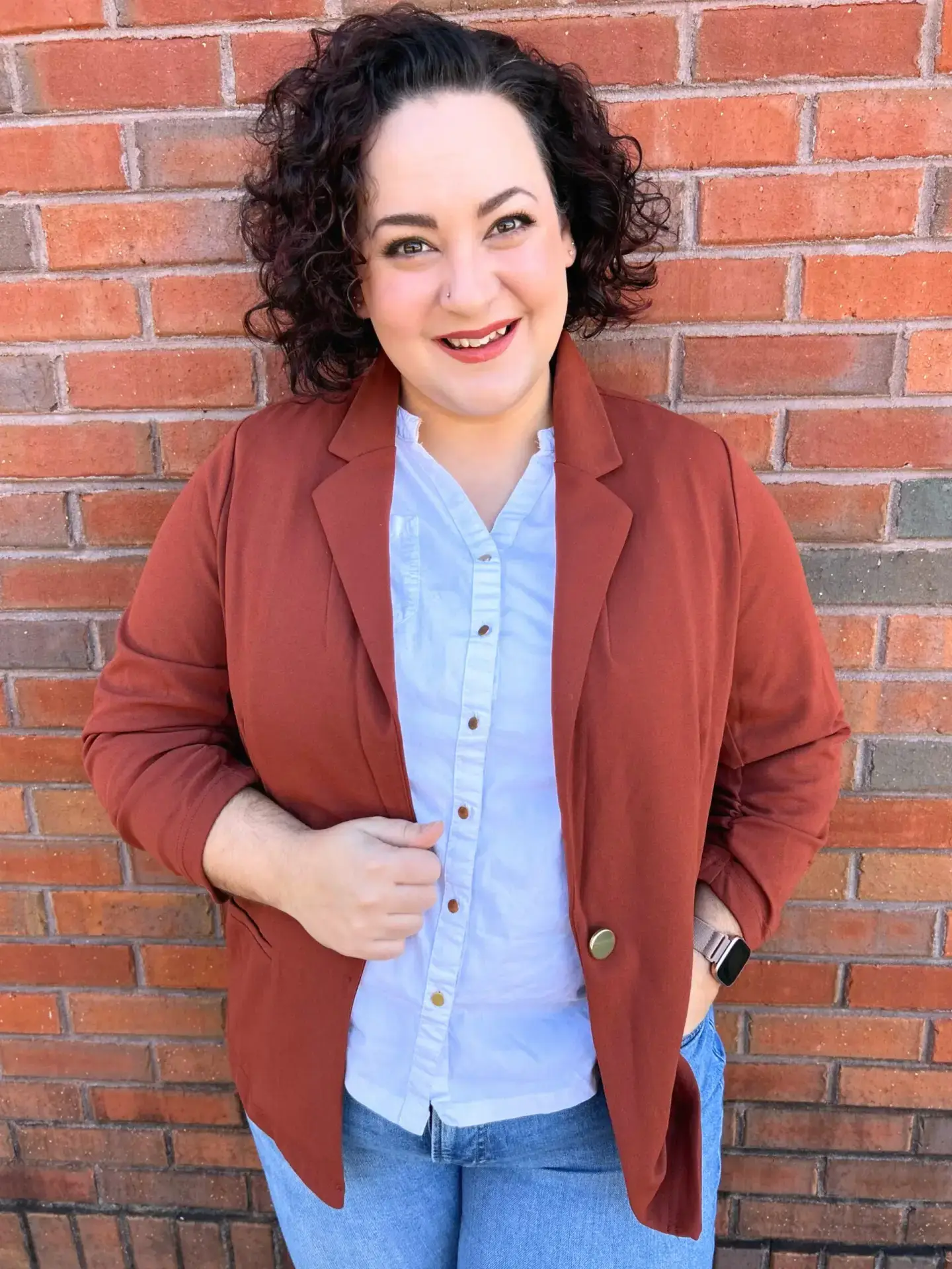 a woman leaning against a wall with her hands on her hips.
