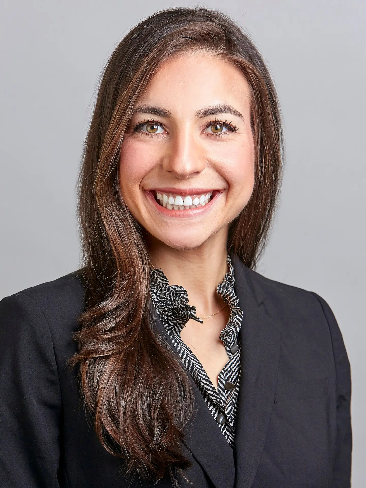 a woman leaning against a wall with her hands on her hips.